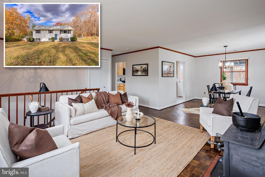 living room featuring a chandelier, baseboards, and crown molding