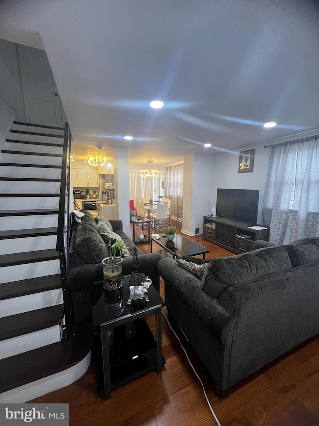 living area with recessed lighting, stairway, and wood finished floors