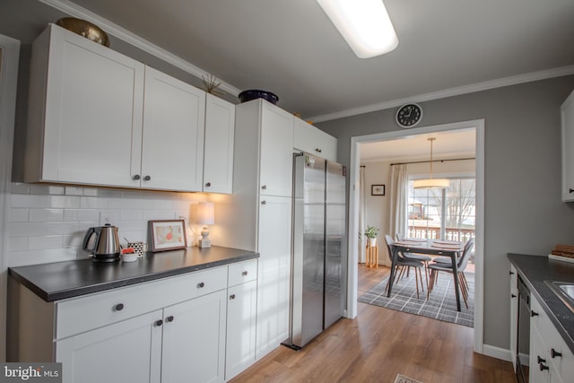 kitchen featuring dark countertops, wood finished floors, and freestanding refrigerator