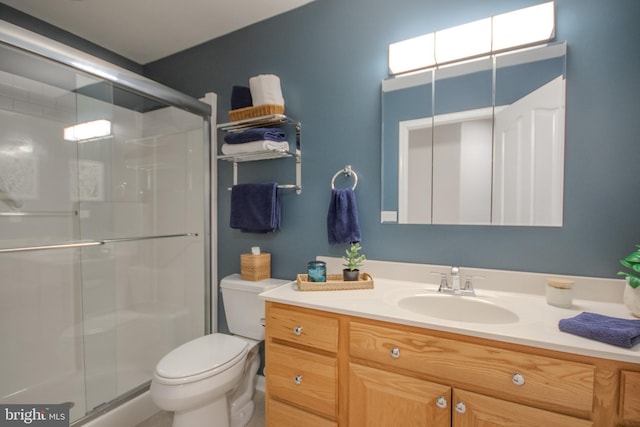 bathroom with toilet, a shower stall, and vanity