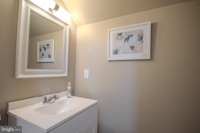 bathroom with lofted ceiling and vanity