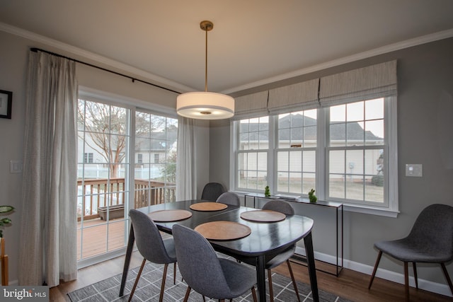 dining area featuring baseboards, ornamental molding, and wood finished floors