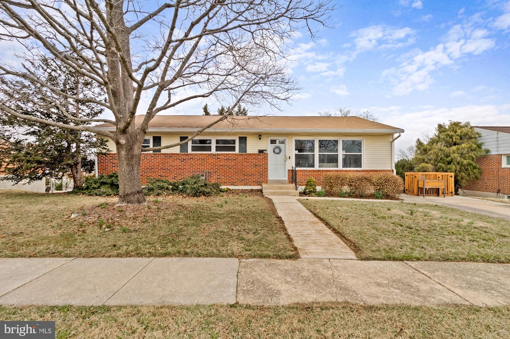 view of front of house with a front yard and brick siding