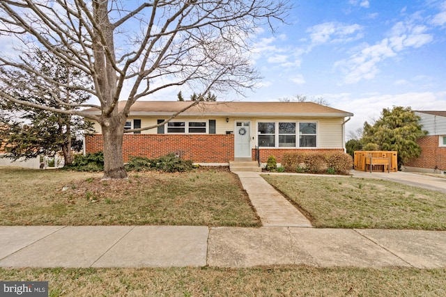 view of front of house with a front yard and brick siding