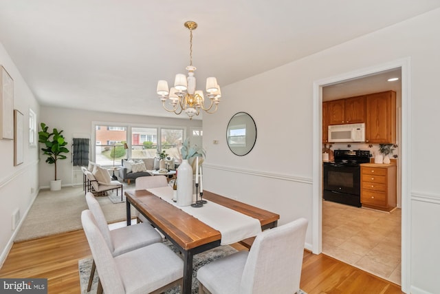 dining space featuring a notable chandelier, visible vents, baseboards, and light wood-style floors