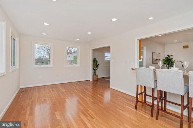 dining area featuring a wealth of natural light, baseboards, and light wood-style flooring