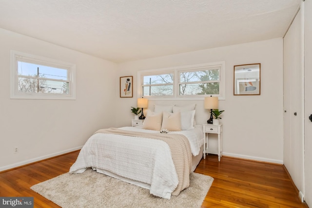 bedroom featuring wood finished floors and baseboards