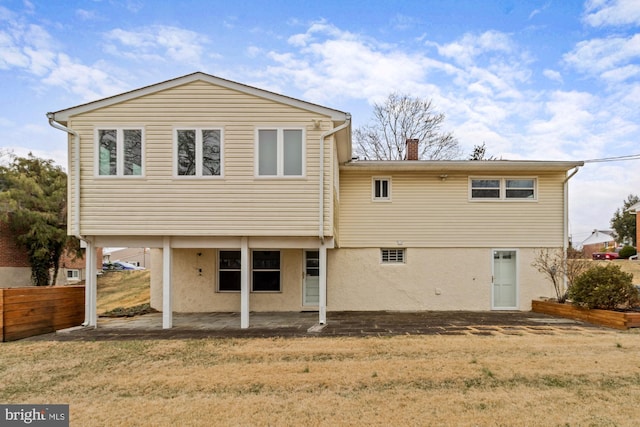 back of house with a patio, a yard, fence, and stucco siding