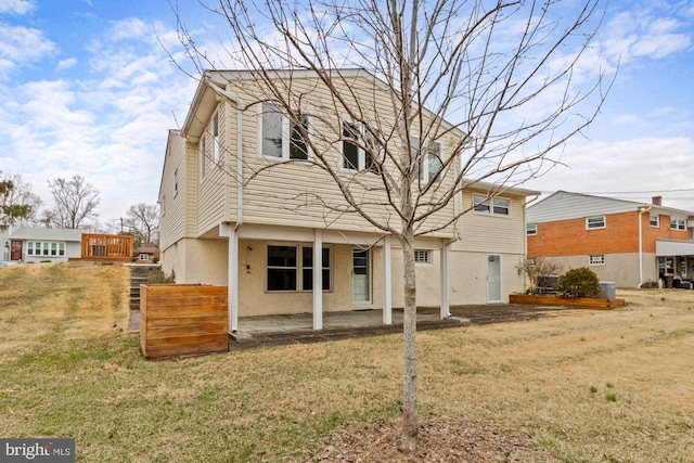 back of house with a patio, a yard, and stucco siding