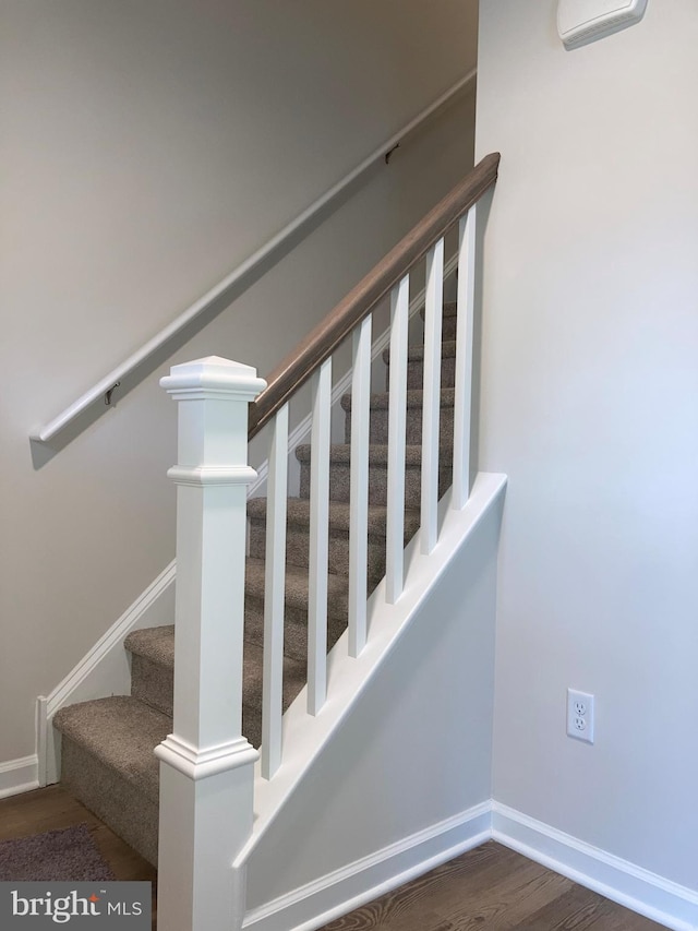 stairway featuring wood finished floors and baseboards