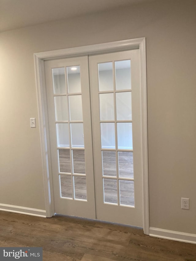 doorway with dark wood-style floors, french doors, and baseboards