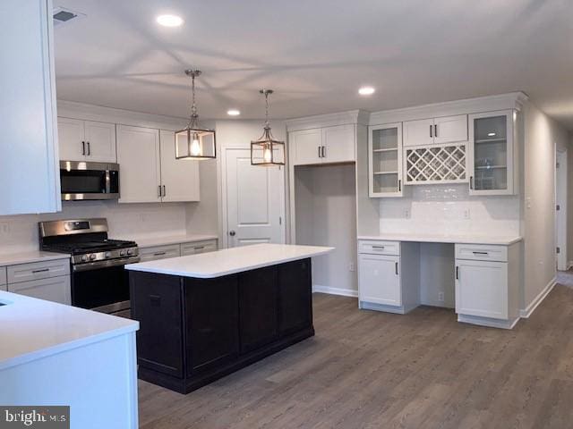 kitchen featuring appliances with stainless steel finishes, white cabinets, and wood finished floors