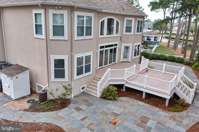 back of property featuring stairs, a shingled roof, a patio area, and stucco siding