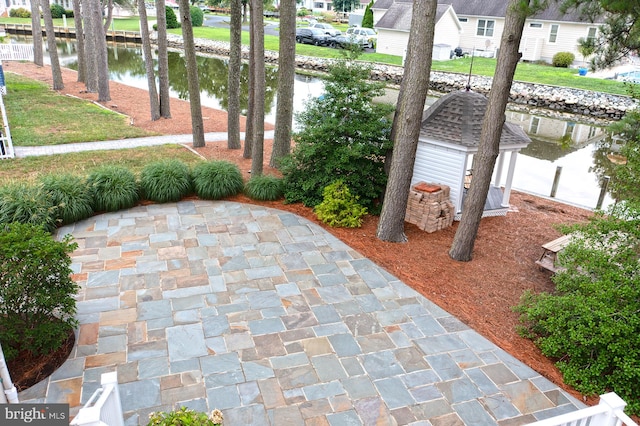 view of patio / terrace featuring an outbuilding and a water view