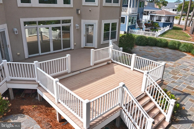 deck featuring a patio area, fence, and stairs