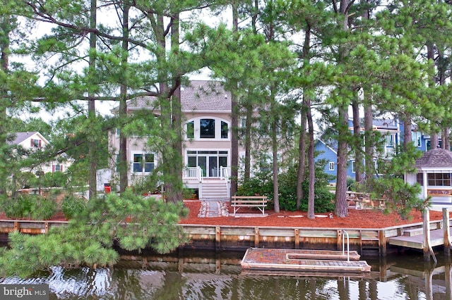 back of property featuring a deck with water view