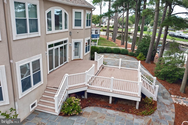 wooden deck with stairway and a water view