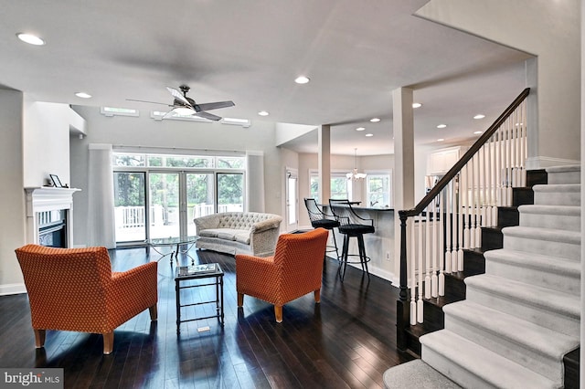 living room with wood-type flooring, stairway, baseboards, and a glass covered fireplace