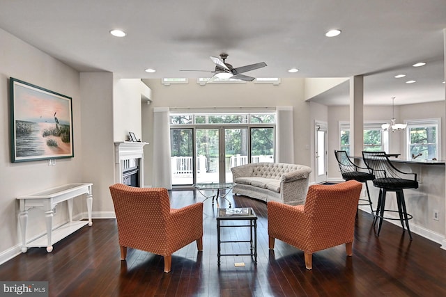 living area with recessed lighting, baseboards, wood finished floors, and a glass covered fireplace