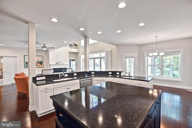 kitchen featuring recessed lighting, a sink, stainless steel dishwasher, a large island, and dark wood-style floors