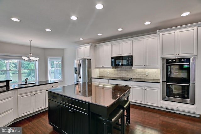 kitchen featuring dark wood-style floors, white cabinetry, a sink, and black appliances