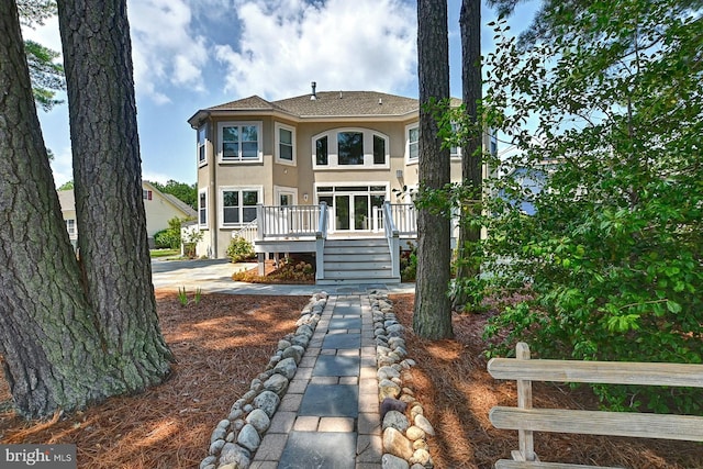 back of property featuring a wooden deck, stairway, and stucco siding