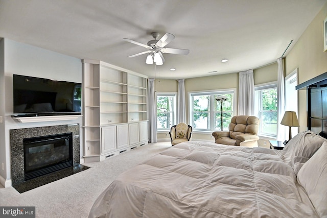 bedroom featuring multiple windows, a premium fireplace, carpet, and recessed lighting