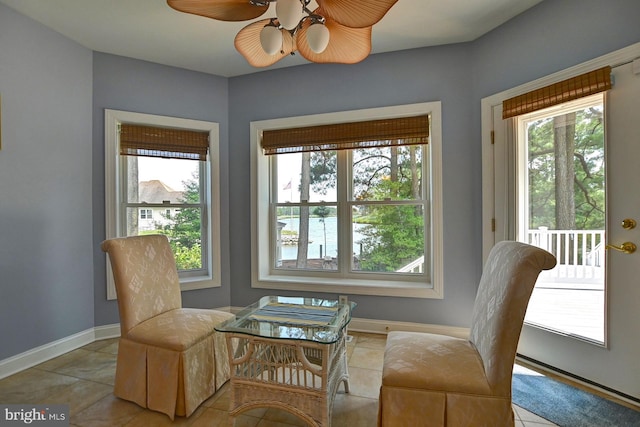 sitting room with baseboards, a ceiling fan, and tile patterned floors