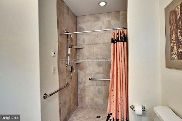 bathroom featuring toilet and tiled shower