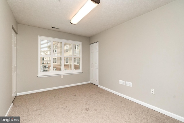 unfurnished bedroom featuring a closet, carpet flooring, visible vents, and baseboards