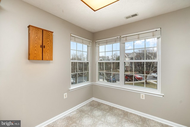 empty room with light floors, baseboards, and visible vents