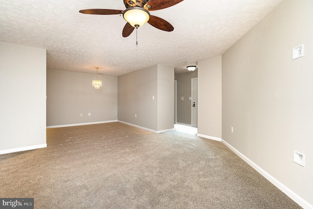 carpeted spare room with baseboards, a textured ceiling, and ceiling fan with notable chandelier