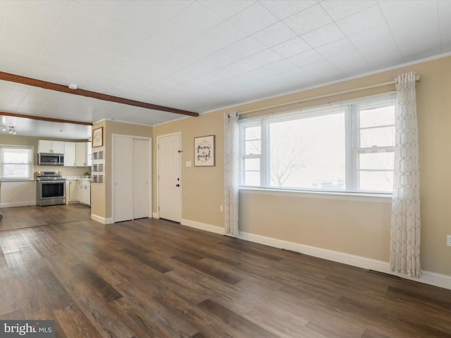 unfurnished living room featuring beamed ceiling, dark wood-style flooring, and baseboards