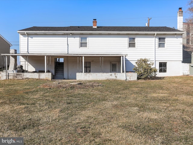 rear view of property with stairs, a chimney, a lawn, and roof with shingles