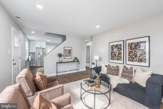 living area with baseboards, visible vents, stairway, wood finished floors, and recessed lighting