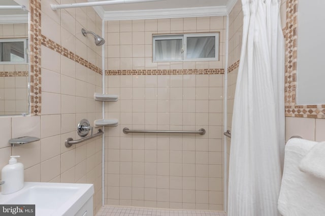 bathroom with tile walls, crown molding, and tiled shower