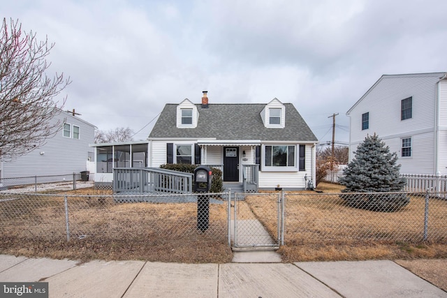 cape cod-style house with a fenced front yard, a gate, and roof with shingles