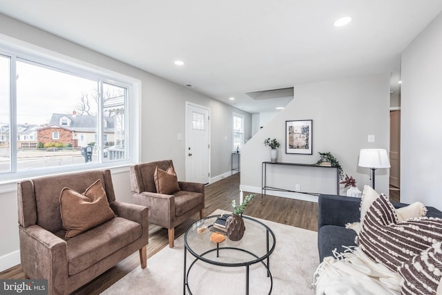 living area featuring baseboards, wood finished floors, and recessed lighting