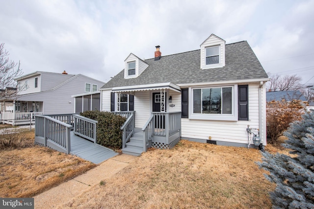 cape cod-style house featuring a chimney and roof with shingles