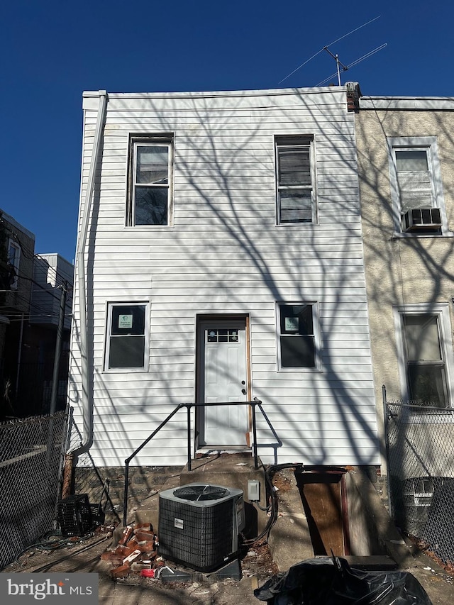 back of property featuring cooling unit, fence, and central AC