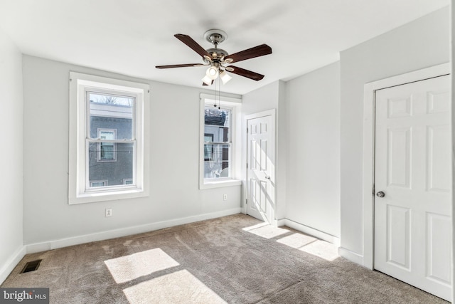 unfurnished bedroom with baseboards, visible vents, ceiling fan, and carpet flooring