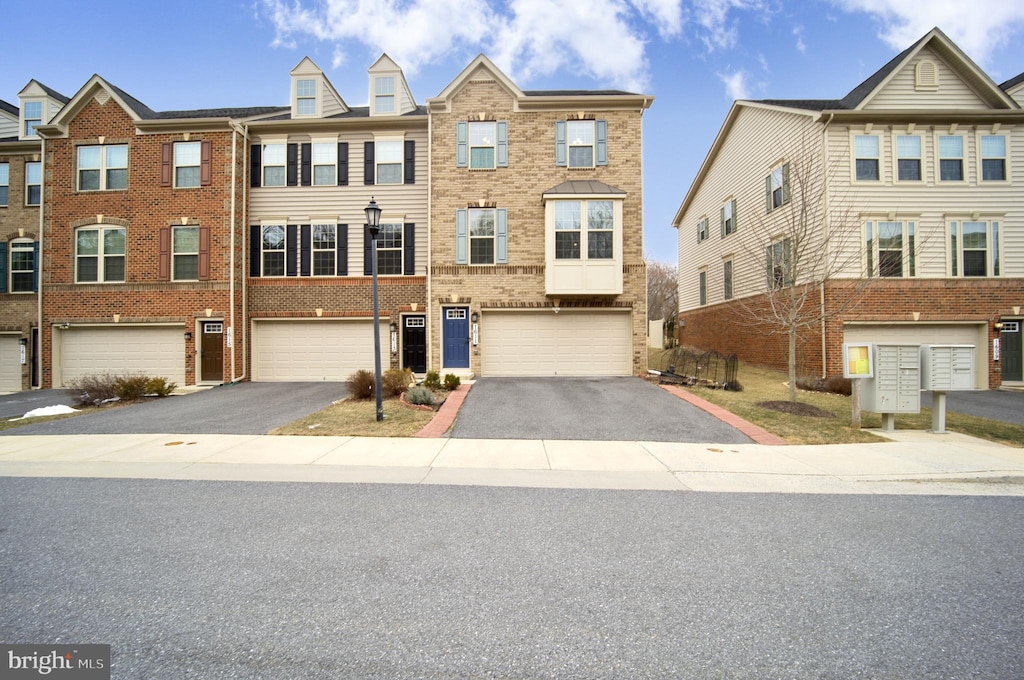 view of property featuring a garage, driveway, and brick siding