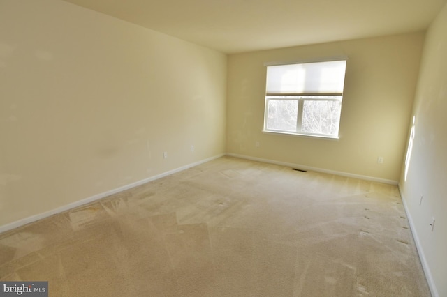 carpeted spare room with baseboards and visible vents