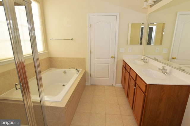 full bathroom with tile patterned flooring, double vanity, a sink, and a bath