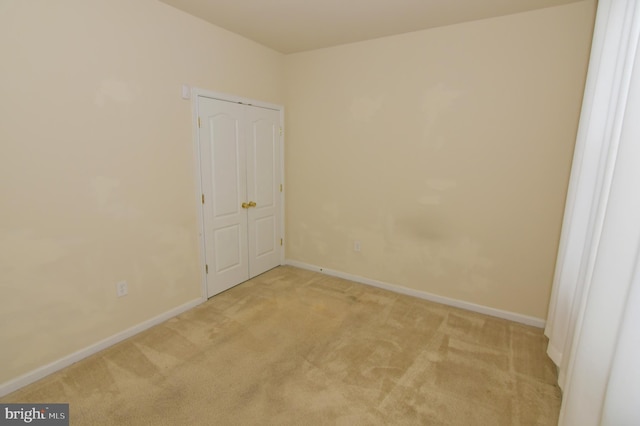 carpeted empty room featuring baseboards