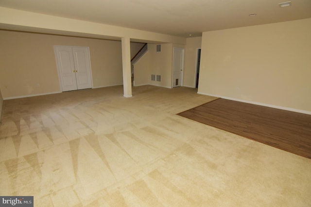 finished below grade area with carpet, stairs, visible vents, and baseboards