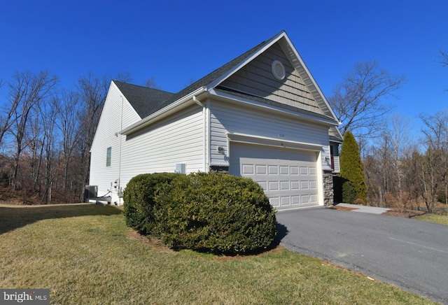 view of side of property with a garage, central AC, aphalt driveway, and a lawn