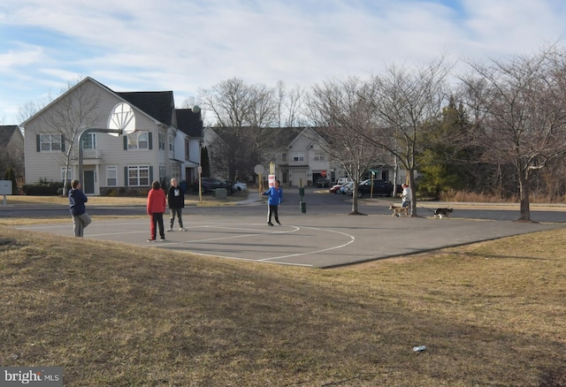 view of basketball court with community basketball court and a lawn