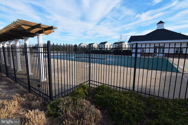 community pool featuring a patio area, a residential view, and fence