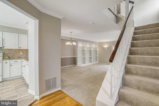 stairway featuring baseboards, visible vents, wood finished floors, and ornamental molding